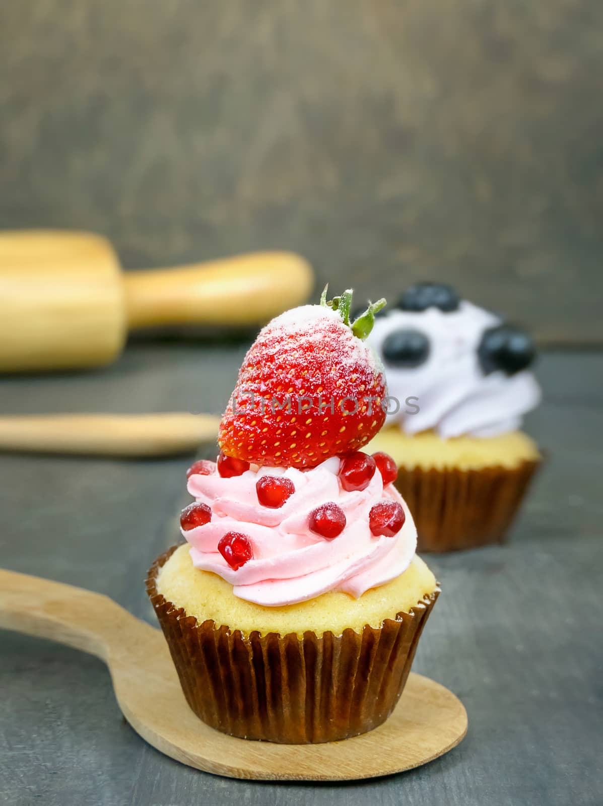 cupcake topped with fresh strawberry and whipped cream