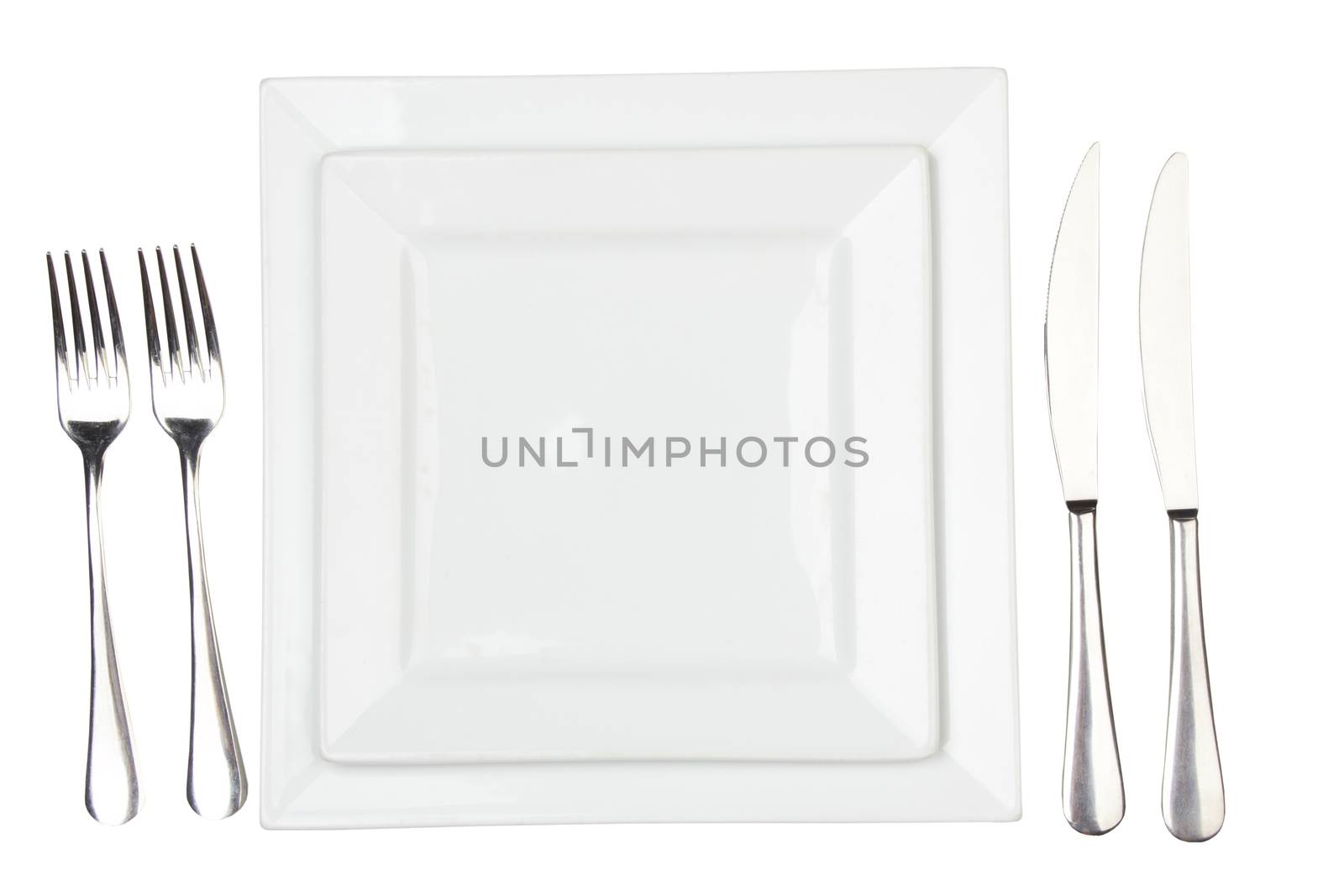 Place setting with high-gloss plate, knife & fork. Isolated on white. 
