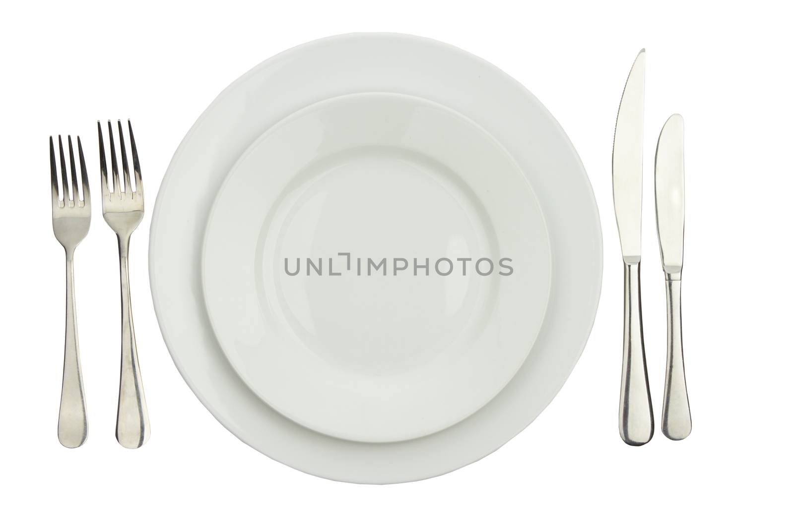 Place setting with high-gloss plate, knife & fork. Isolated on white. 

