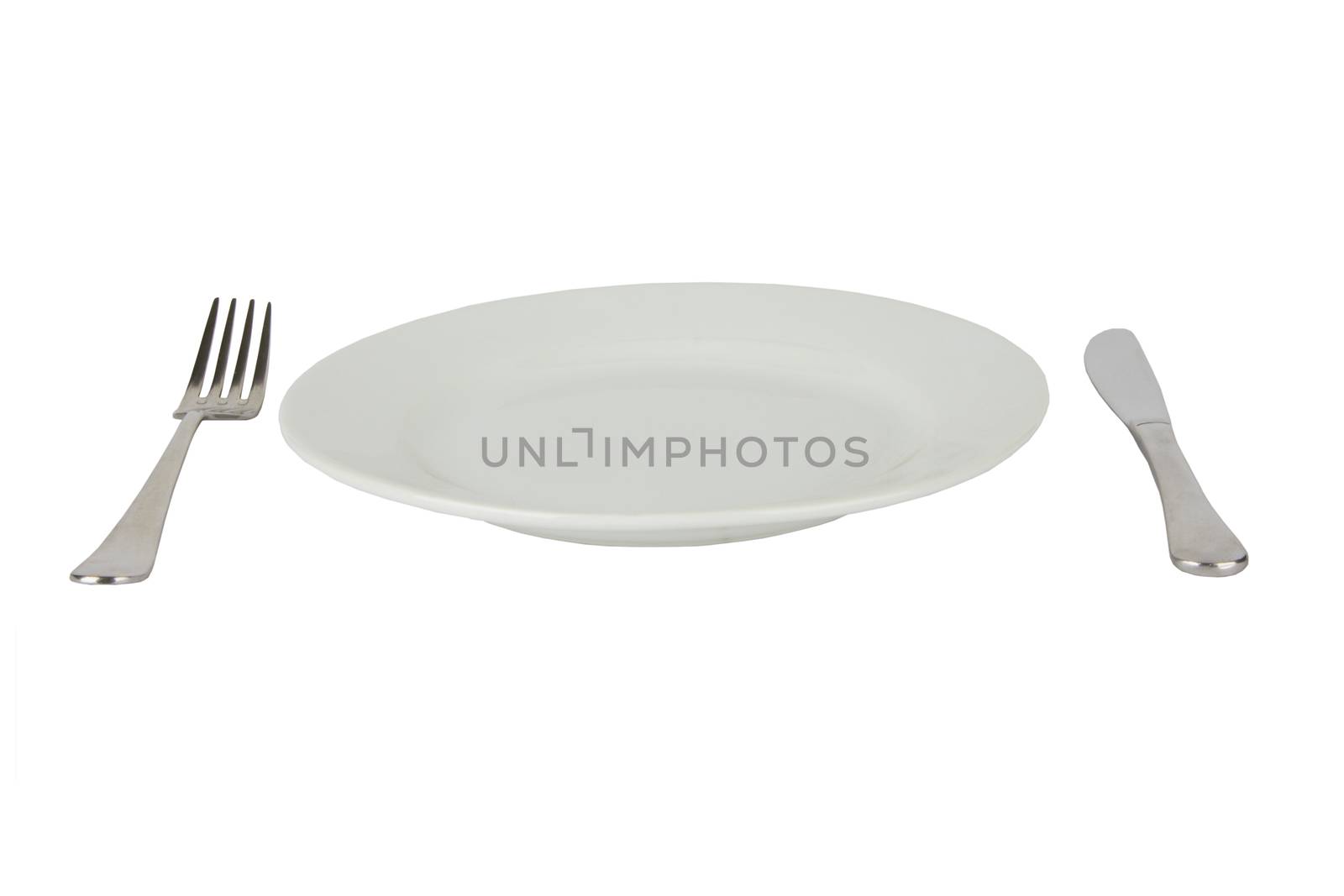 Place setting with high-gloss plate, knife & fork. Isolated on white. 