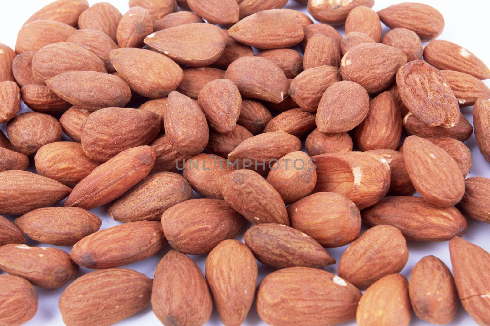 Heap of almond nuts on white background