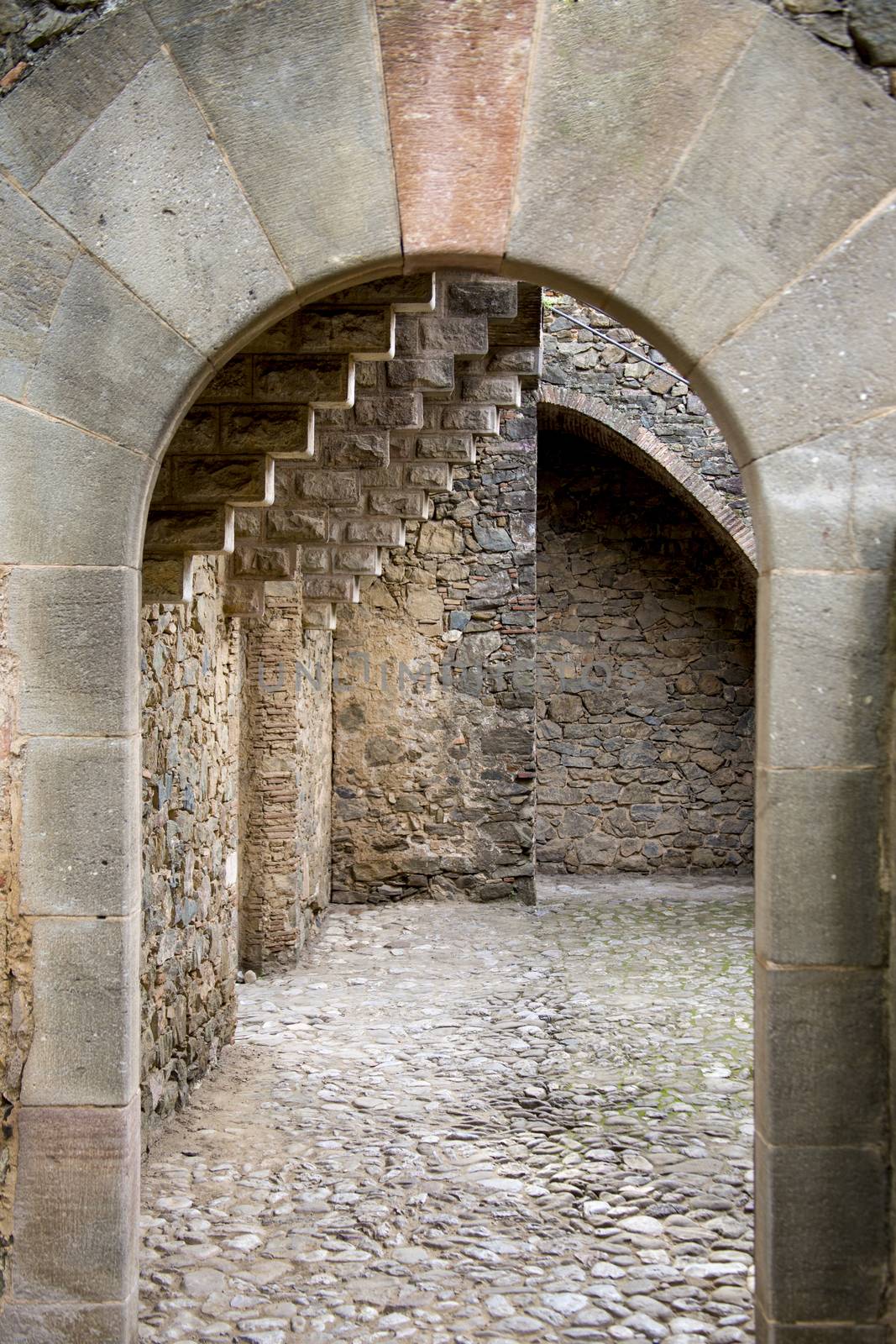 Architectural arch of natural stone, leading to the courtyard with stone paving of the Torre Bellesguard, built by the great Spanish architect Antoni Gaudi.