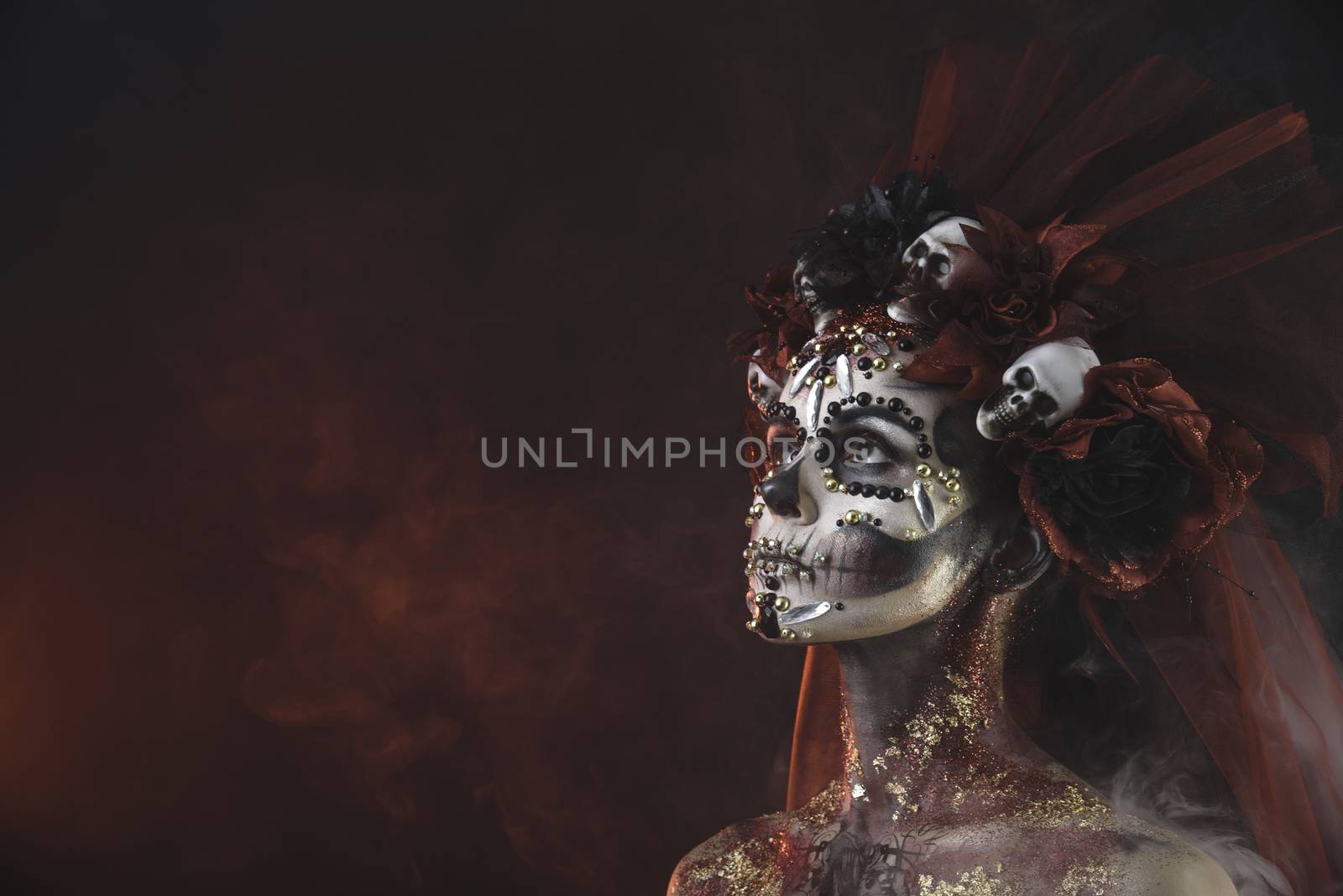 Santa Muerte Young Girl with Artistic Halloween Makeup and with Sculls in her Hair