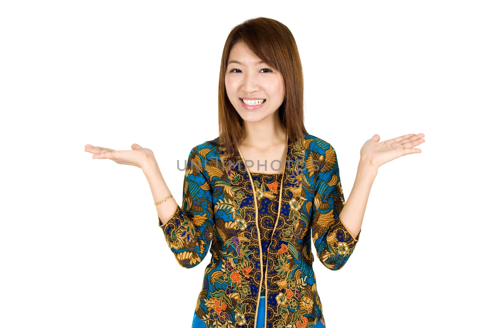 Southeast Asian girl with batik kebaya clothes holding hand showing something, standing isolated on white background.