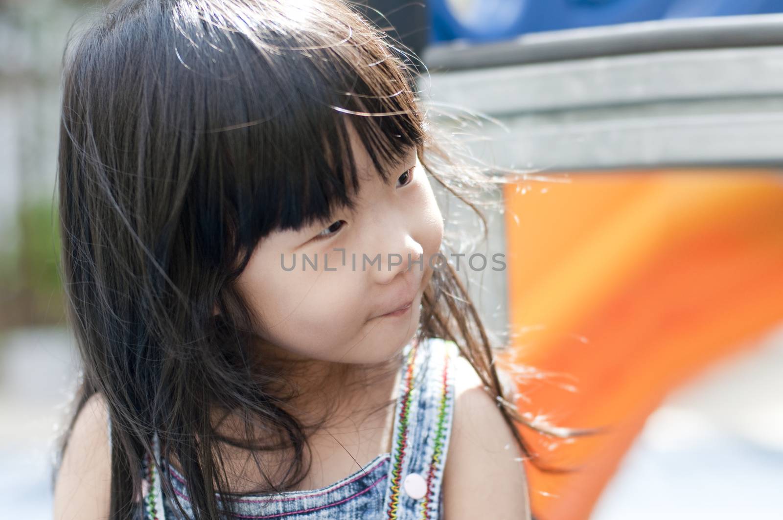 Candid moment of cute little Asian girl having fun in playground.