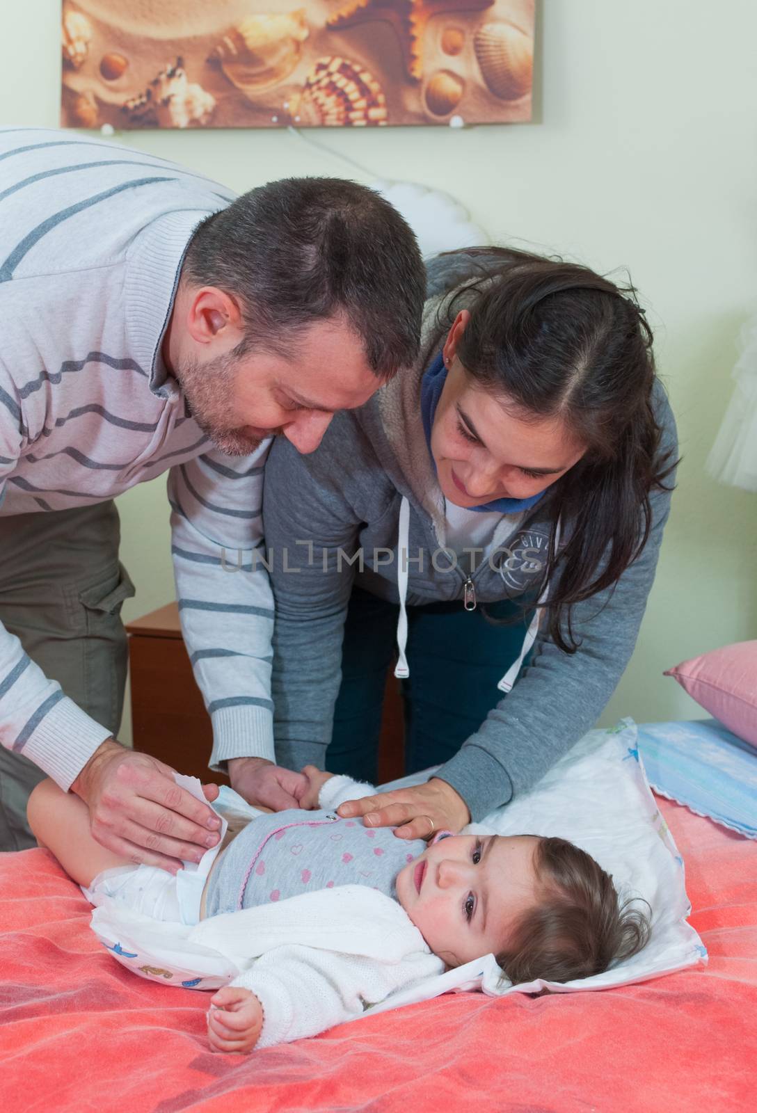 Couple, man and woman change diaper of a baby by easyclickshop