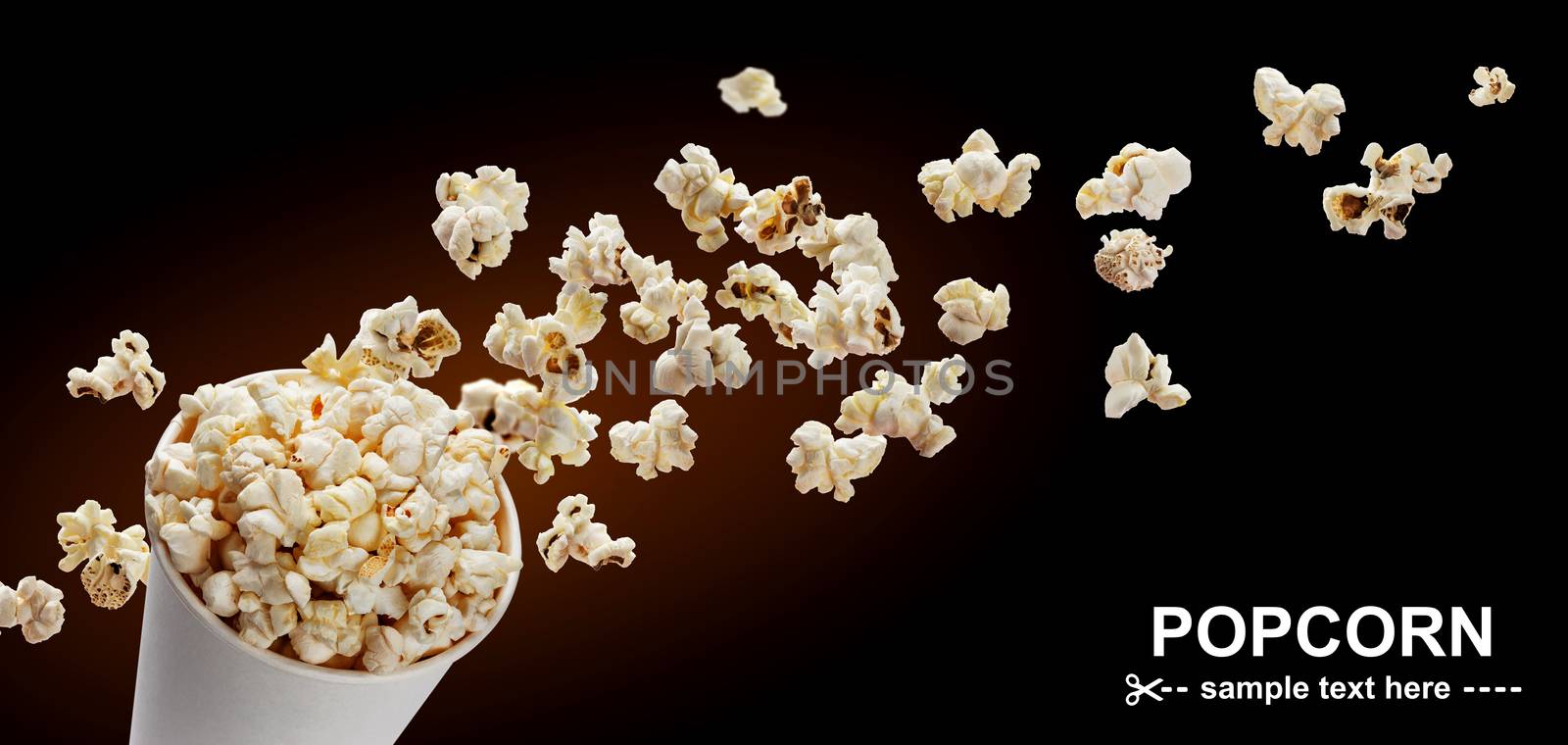 Popcorn in cardboard box, isolated on black background with copy space