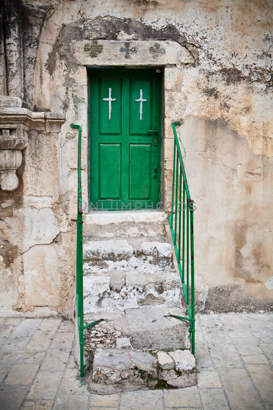 Green church door in back of the holly sepulcher church in jerusalem