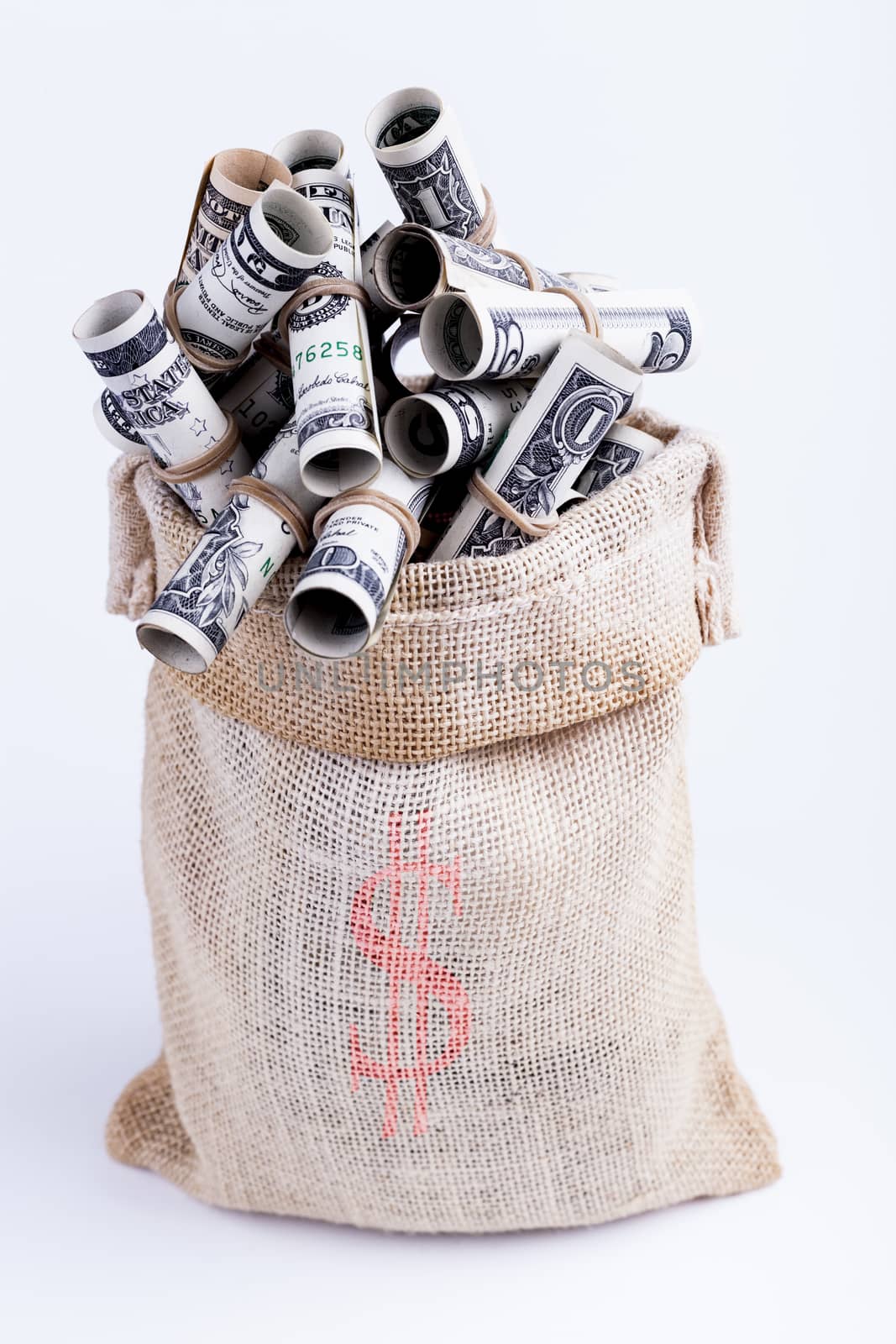 Dollars rolled up with rubber band in Sack brown isolated on white background