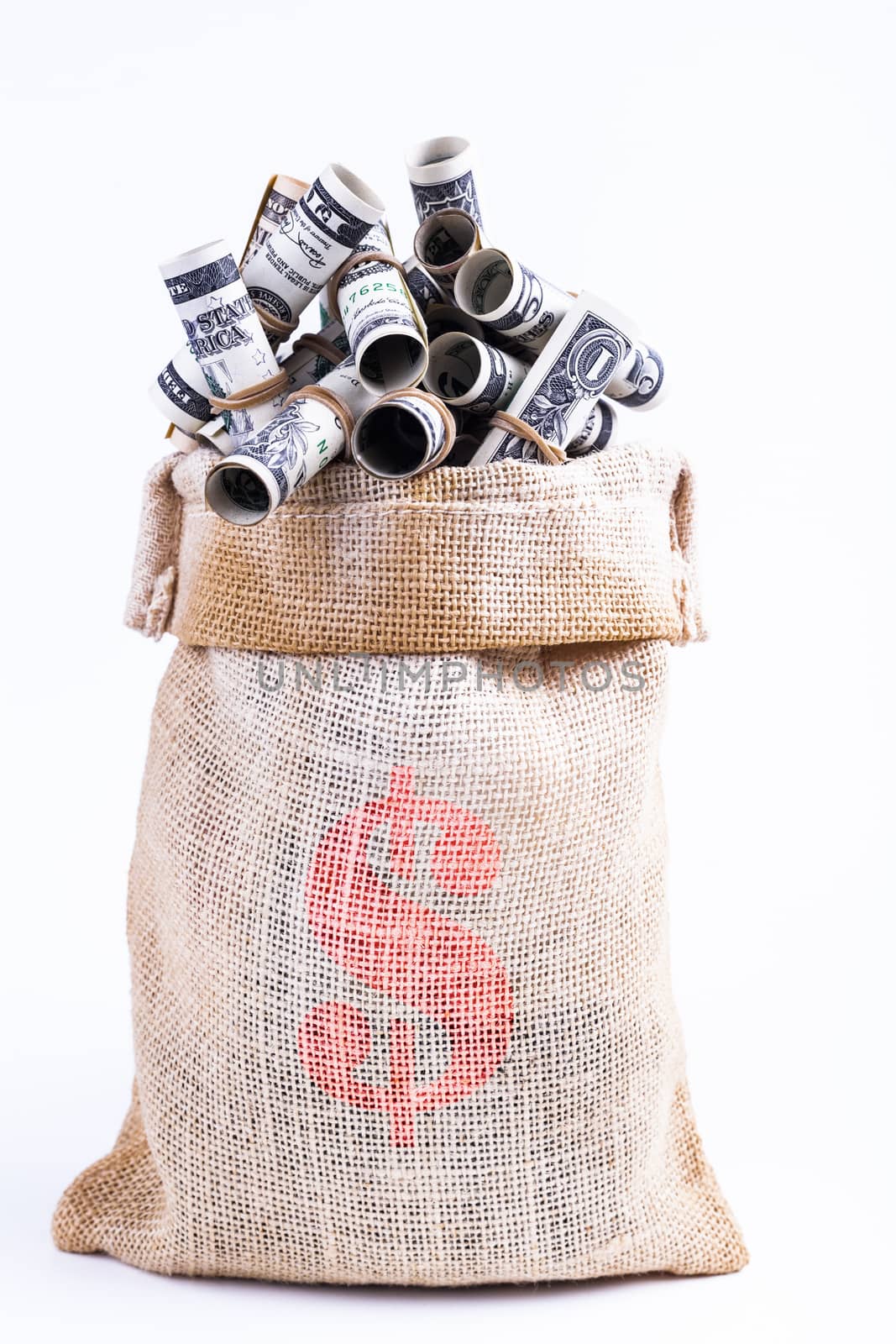 Dollars rolled up with rubber band in Sack isolated on white background