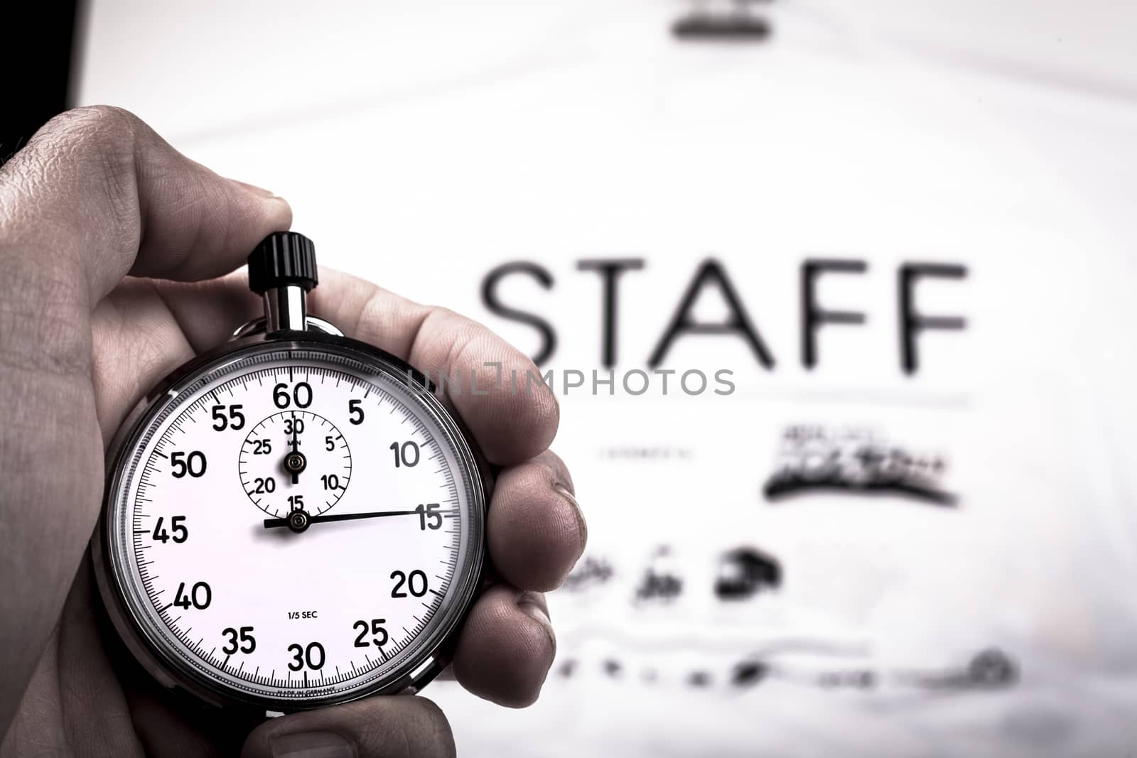 Silver vintage metalic chronometer in a hand with a white staff shirt in the background