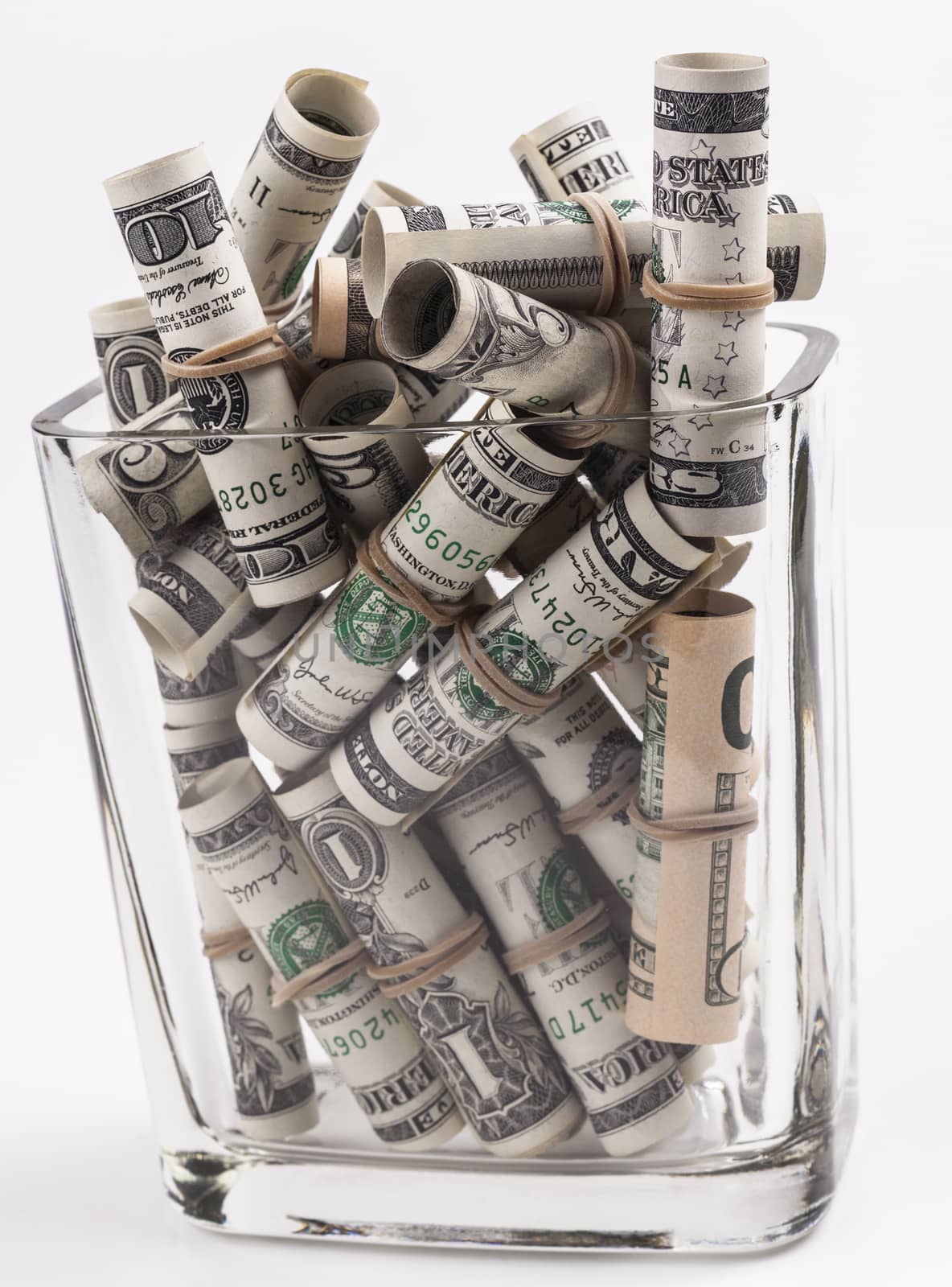 Dollars rolled up with rubber band in jar isolated on white background