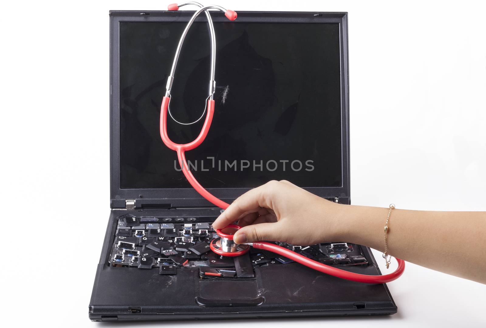 Hand examining broken laptop with red stethoscope isolated on white background