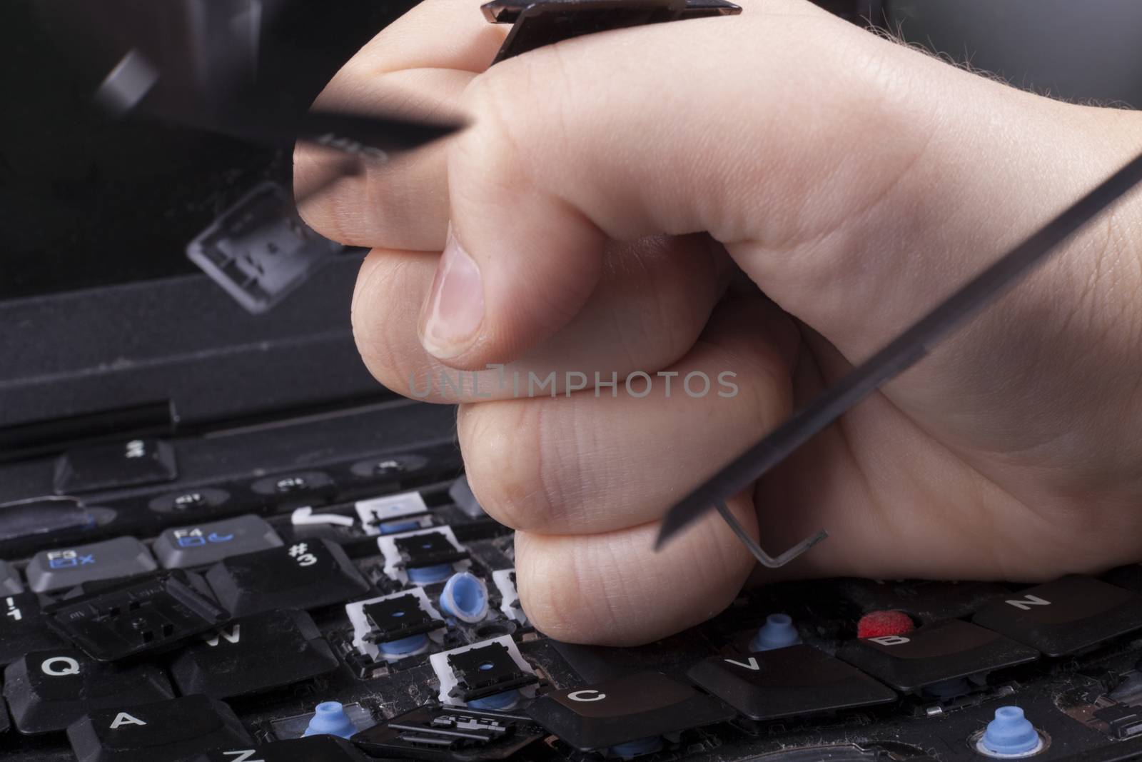 Woman braking laptop keyboard with her fist