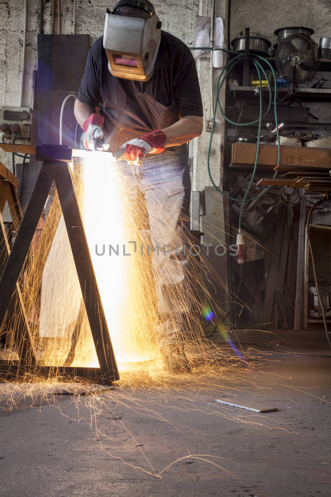 Plasma cutting in a metal workshop with man in action