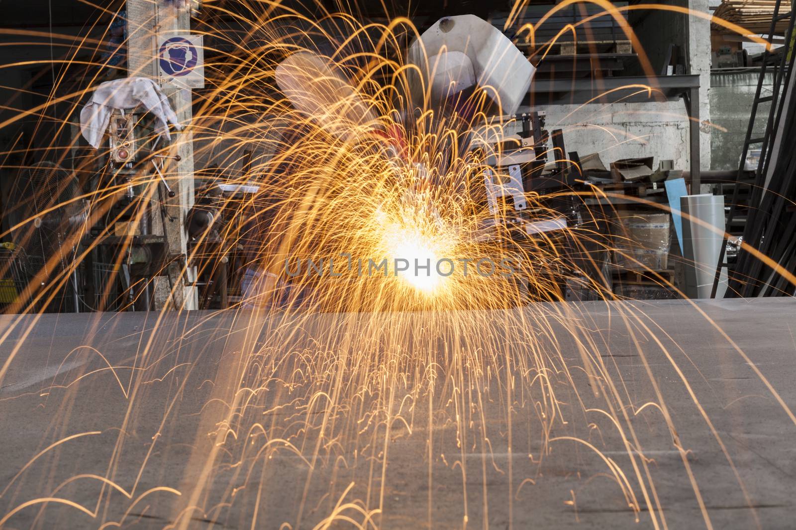 Worker Grinding metal in a workshop with sparks flying