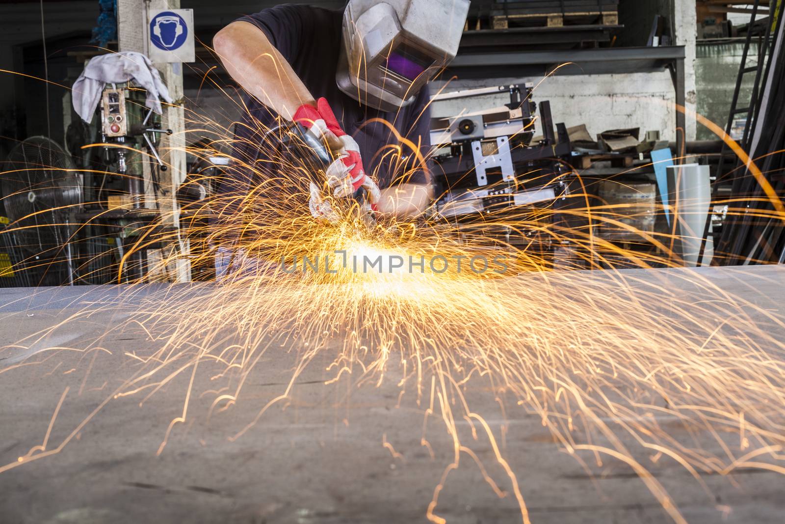 Worker Grinding metal in a workshop with sparks flying