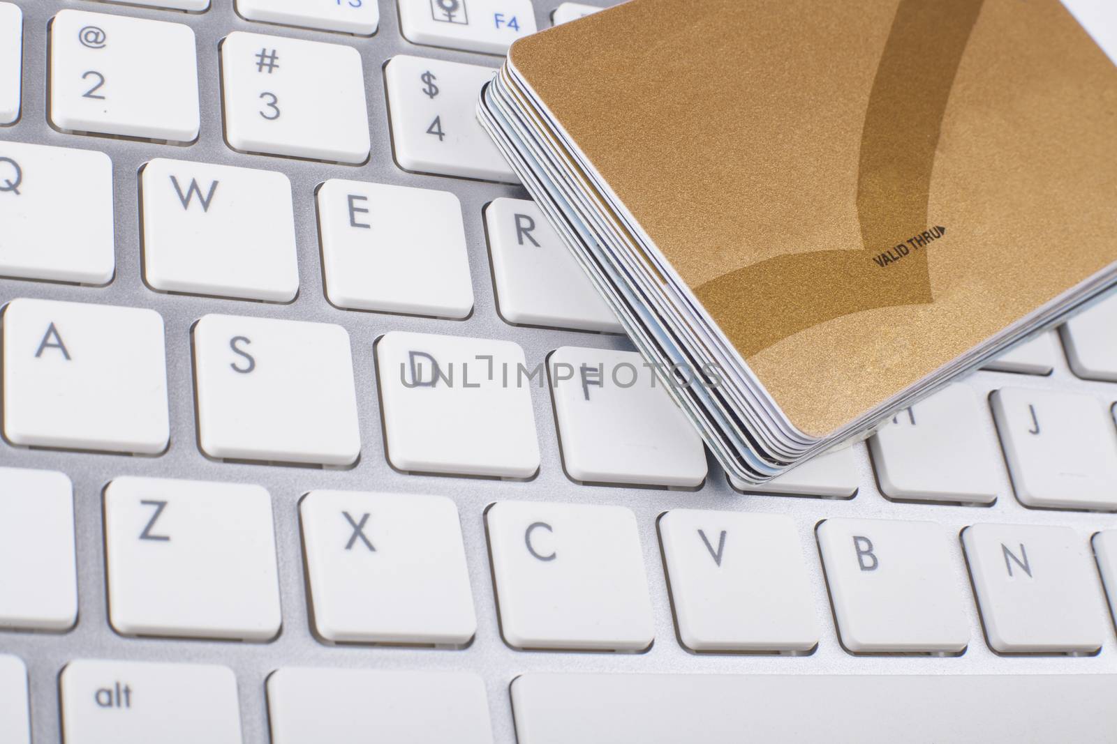 Credit cards stack on white and silber computer keyboard 