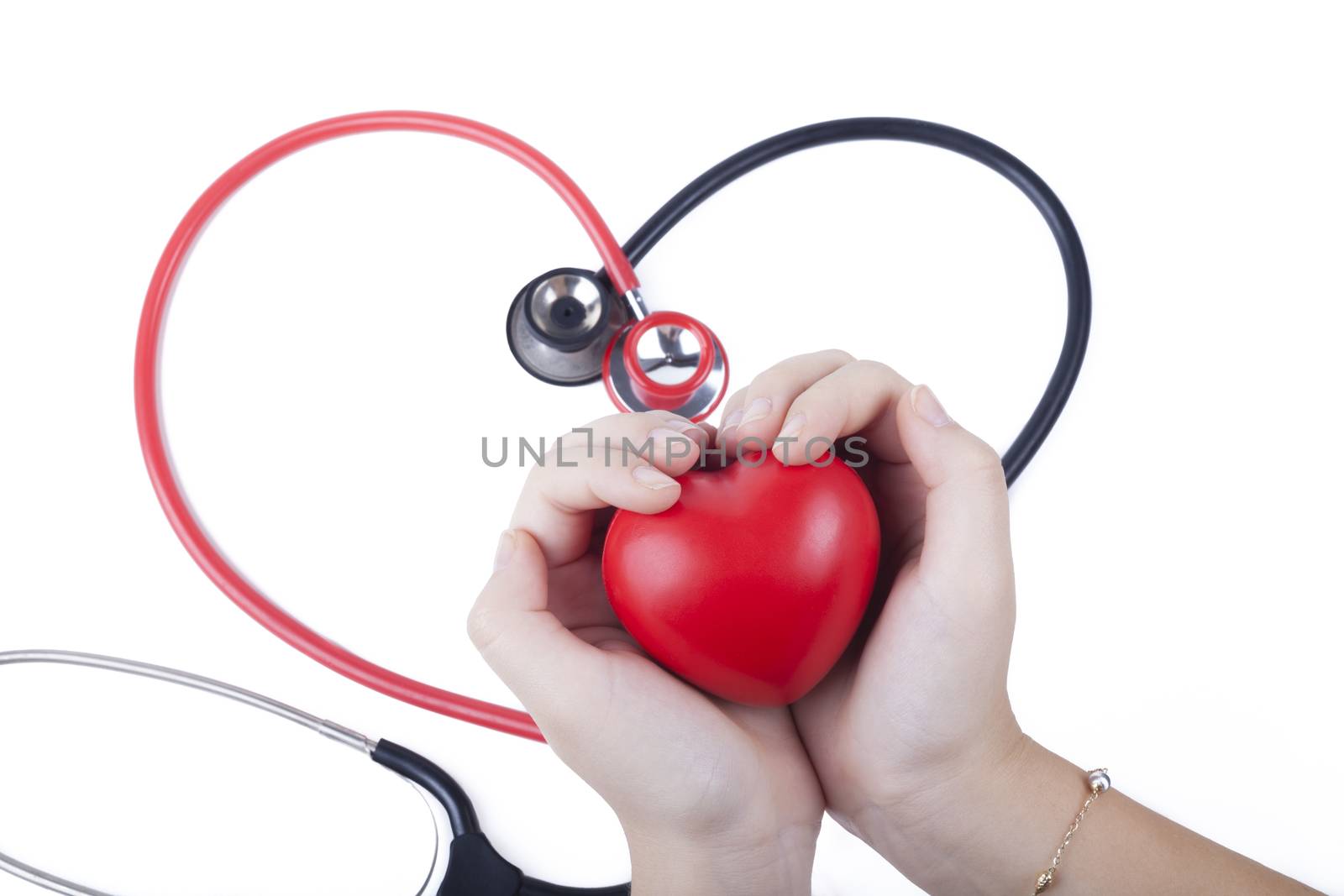 Red Heart in female hand wth two  stethoscopes in the background isolated on white