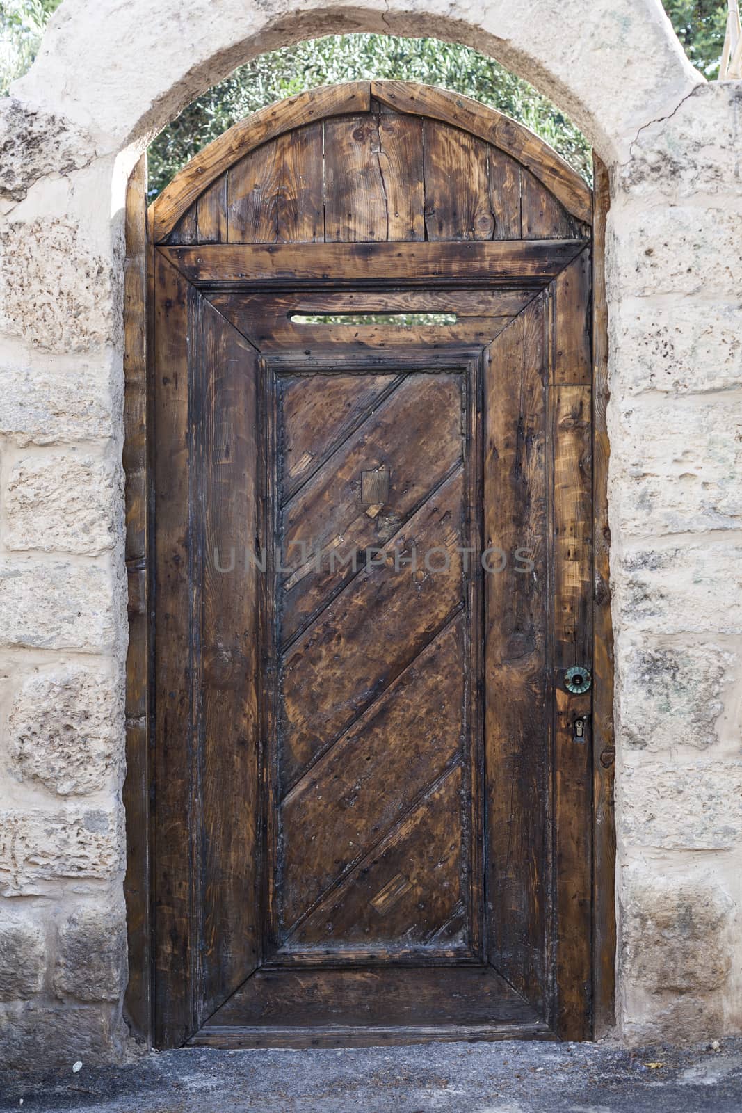 Old brown wood entrance door with white brick wall