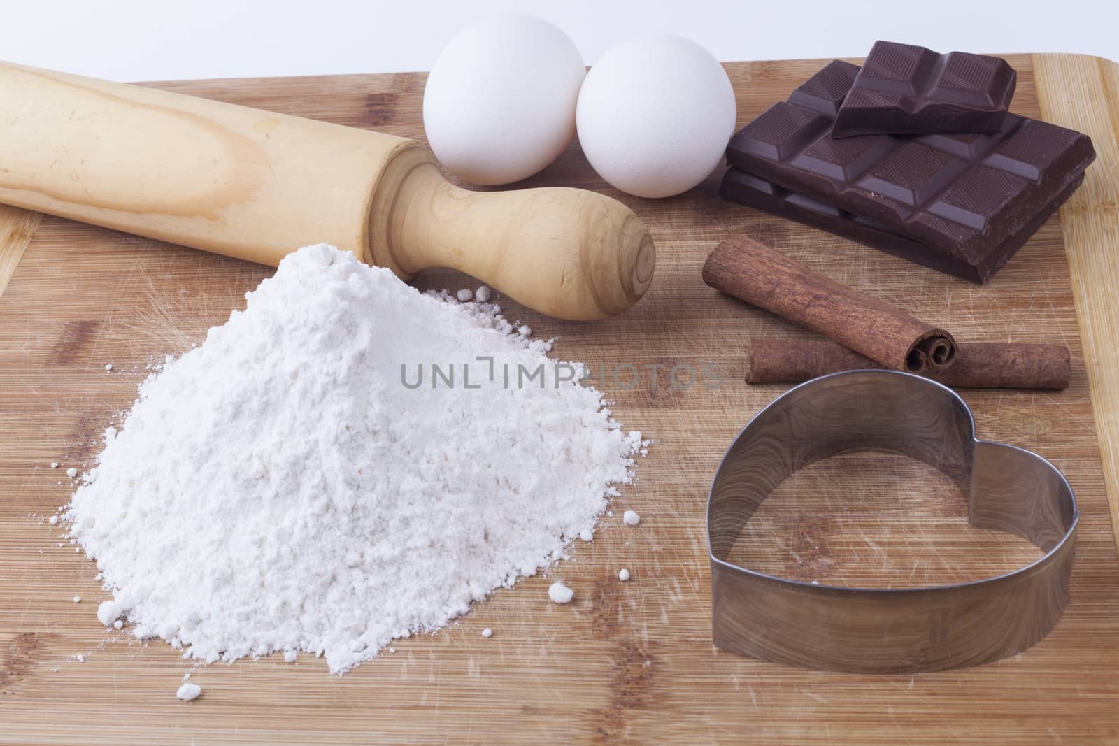 Baking ingredients an ustensils on brown wod board