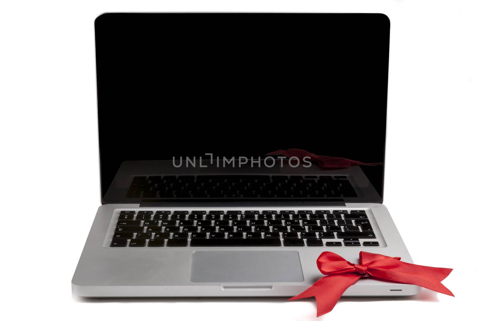 Silver Laptop with blank black screen and red bow on the keyboard isolated on white background