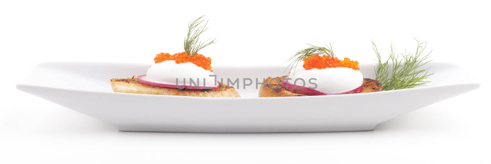 Red caviar in a long plate isolated on white background