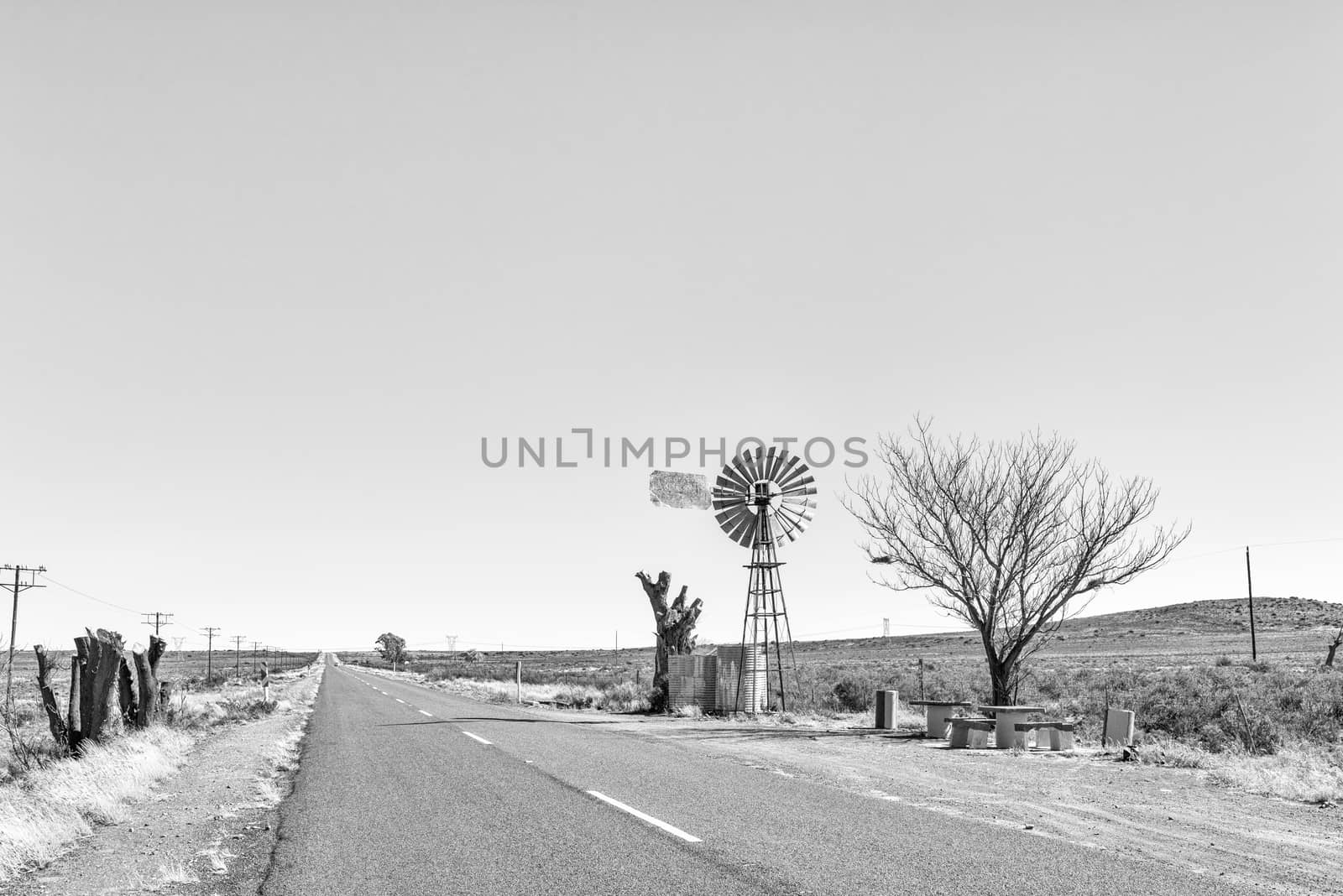 Monochrome view of a water-pumping windmill and picnic spot on road R48 between Phillipstown and De Aar in the Northern Cape Province