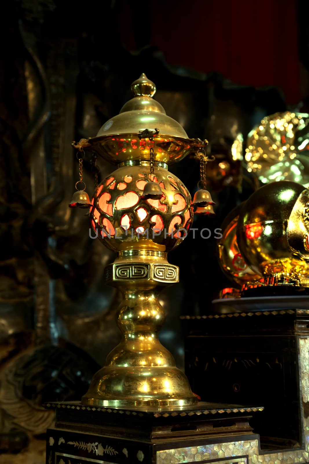 Gild lamp in a darkness of a buddhist Temple, Vietnam