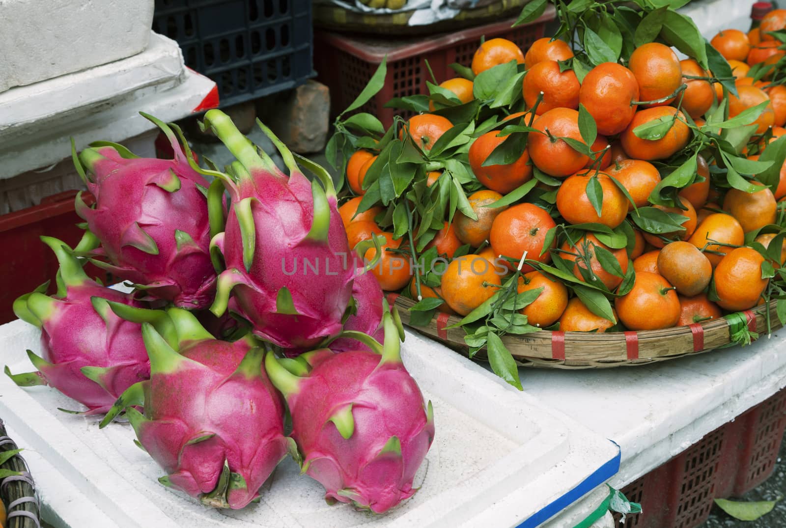 Dragon fruits and tangerines at a market in Hanoi, Vietnam