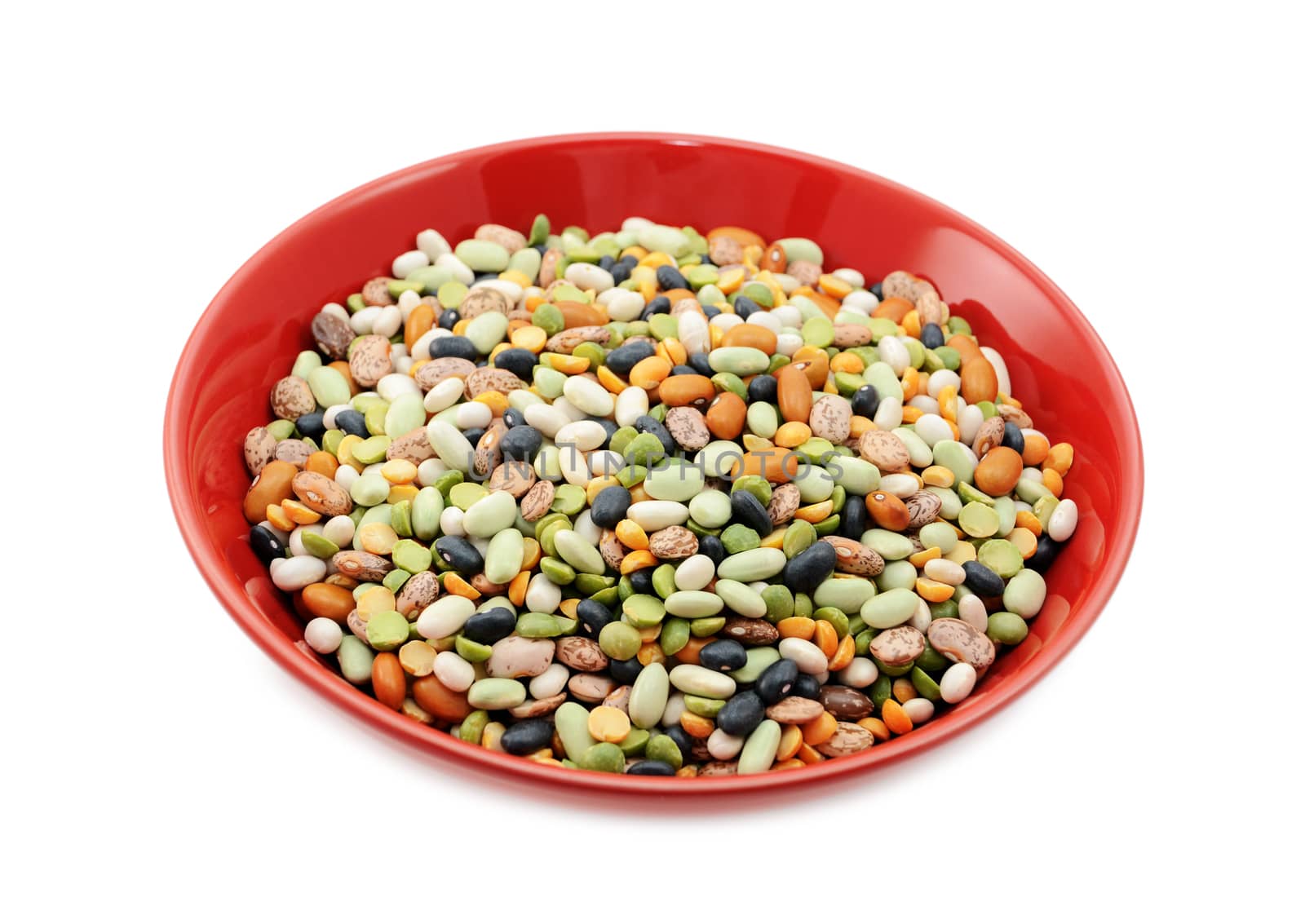 Mixed dried beans and peas in a deep red china bowl, on a white background