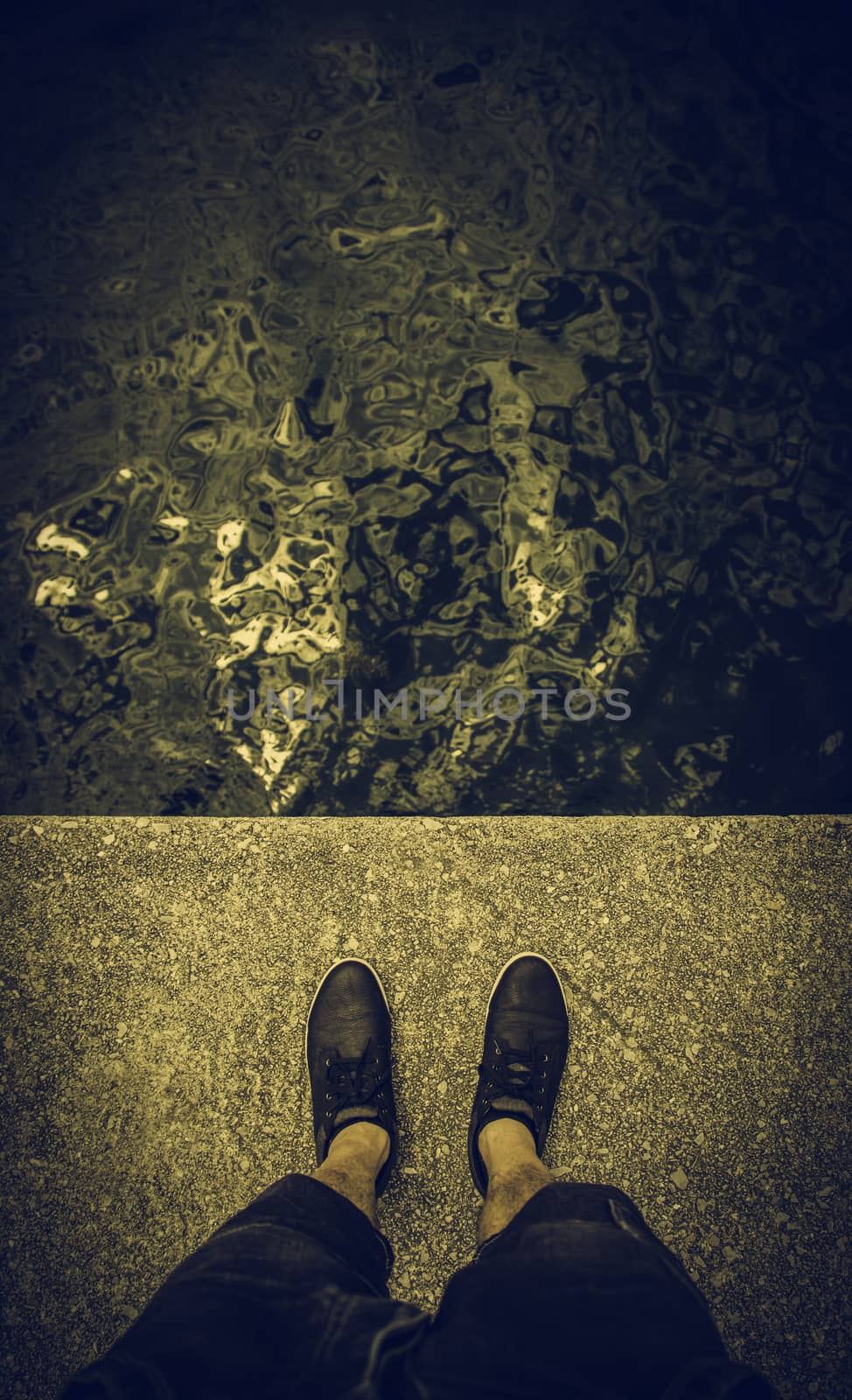 Feet on the water's edge, detail of exploration and contemplation