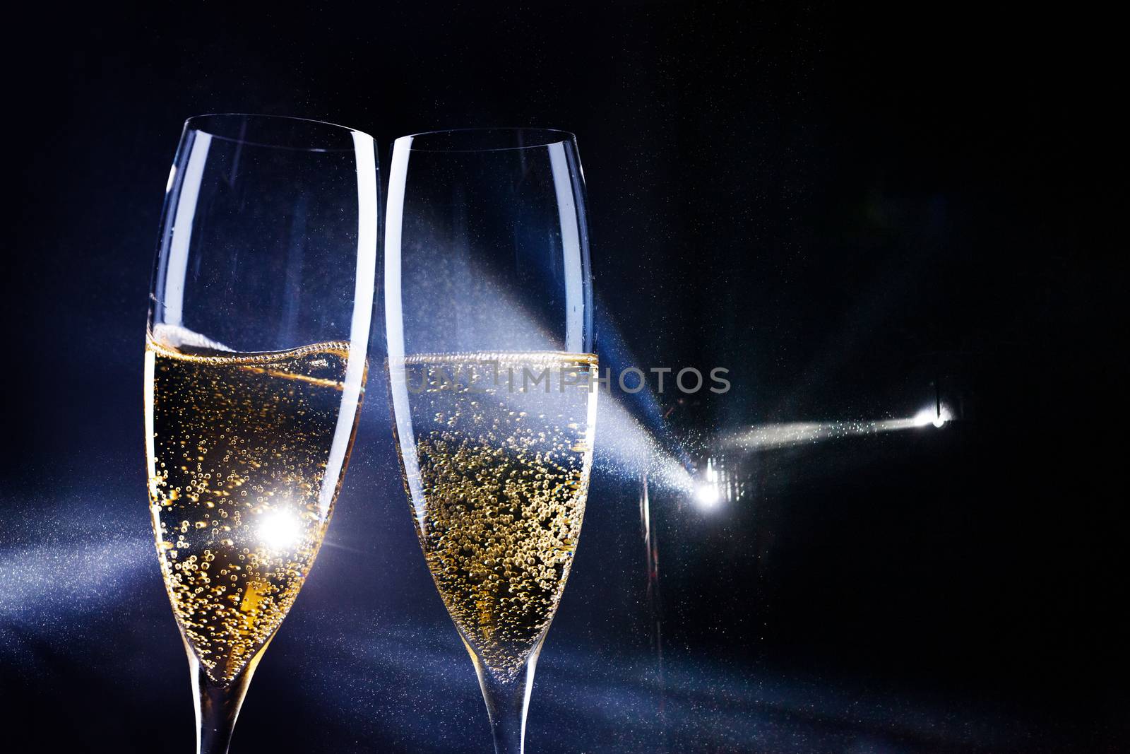 two glasses of champagne in the spotlight - new year celebration