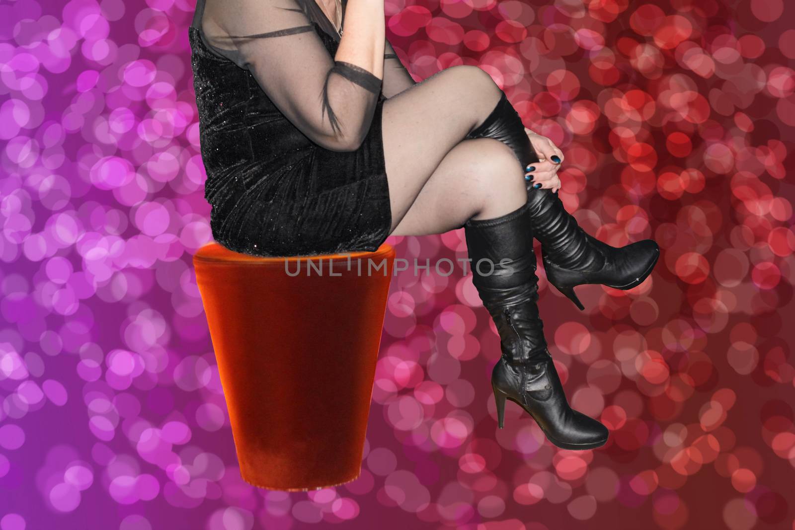 Woman in sexy black dress is sitting on a red barstool   by JFsPic