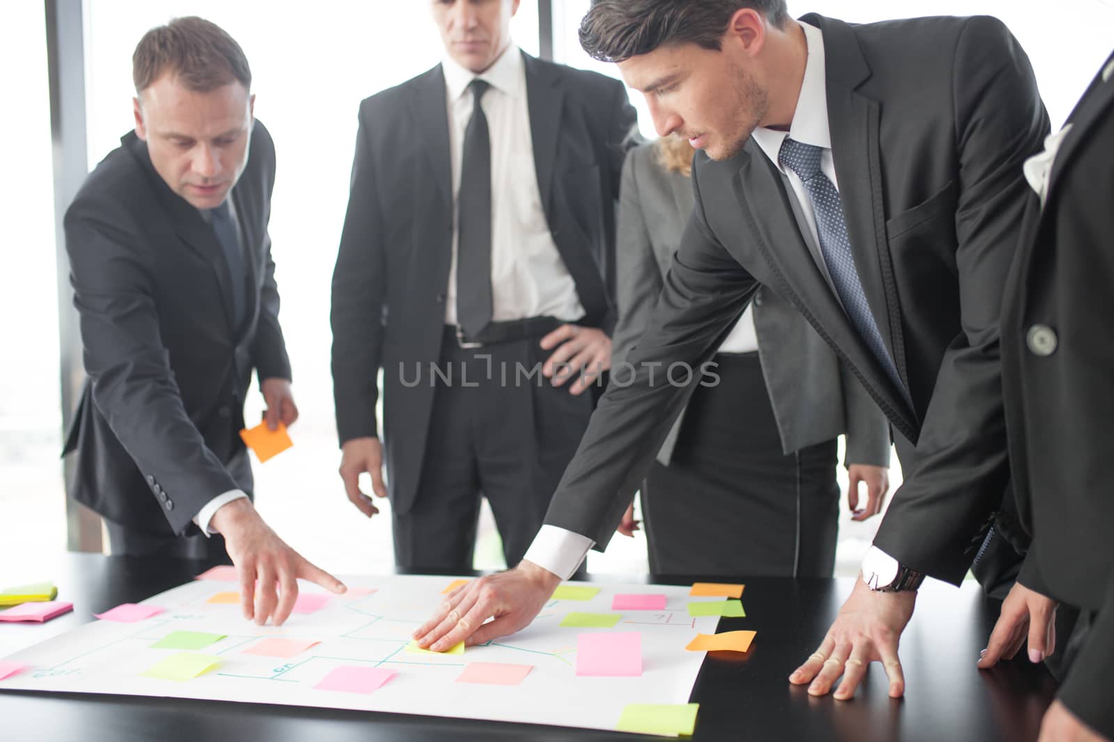 Business people team developing plan on office desk using stick notes