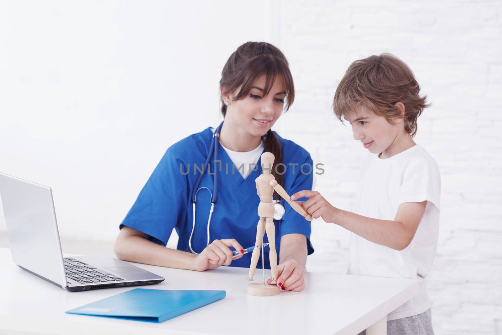 Doctor explain medicine to child using wooden doll