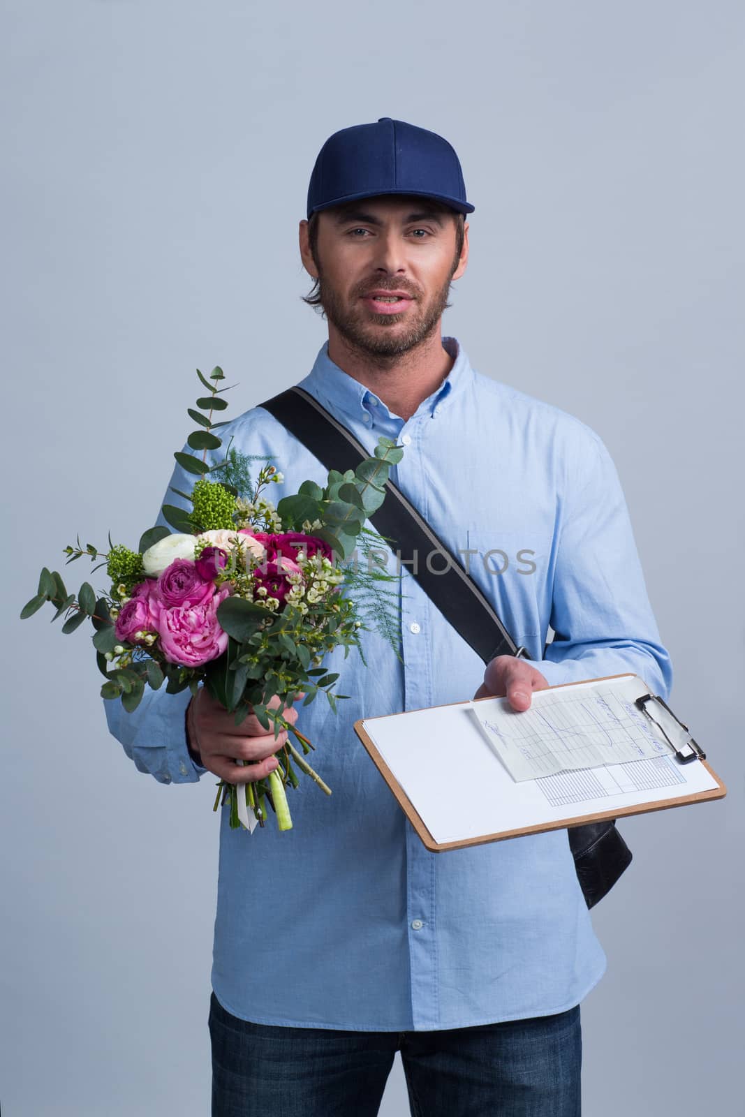 Delivery man holding flower bouquet and form