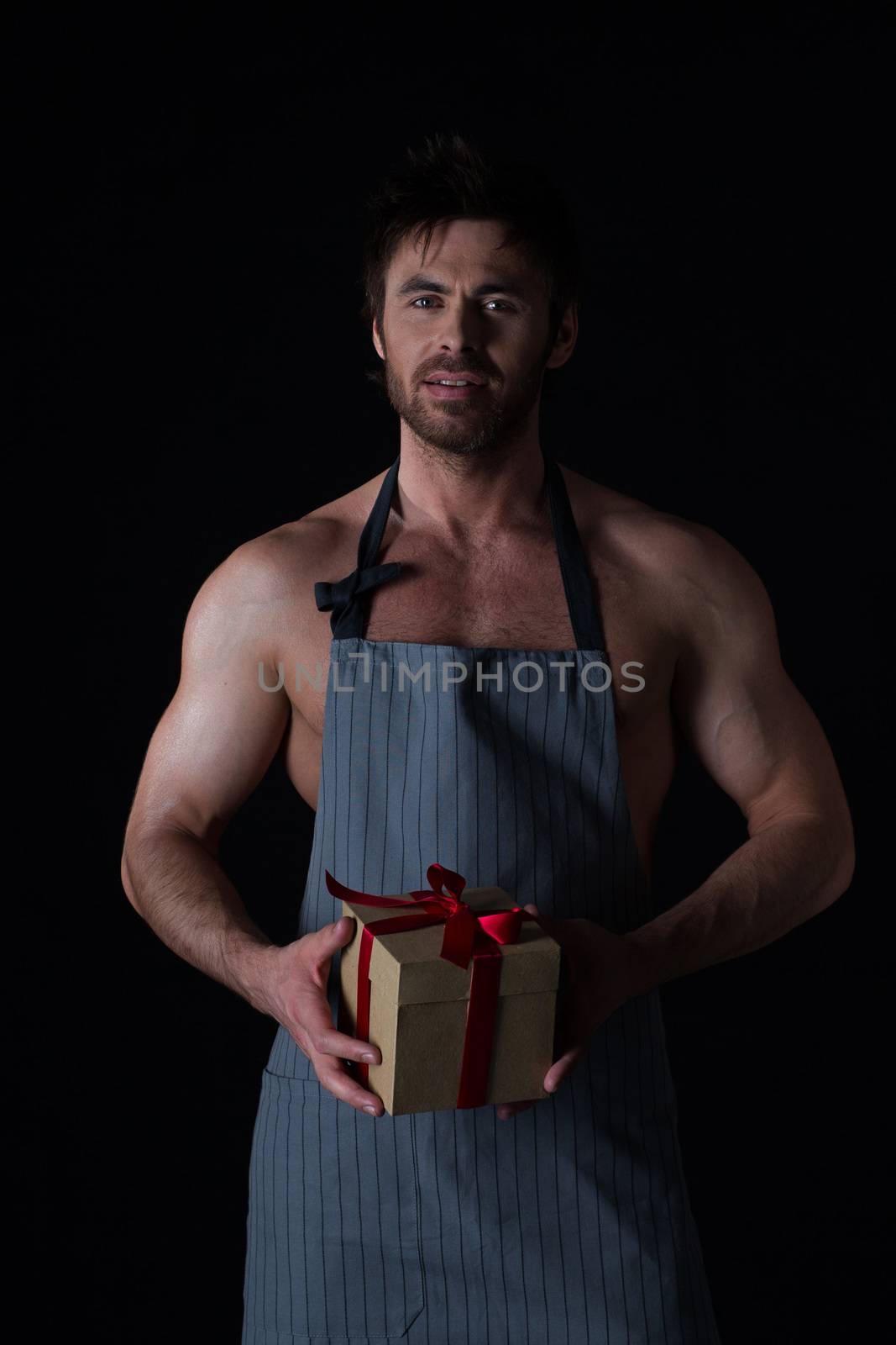 Muscular man in apron holding gift by ALotOfPeople