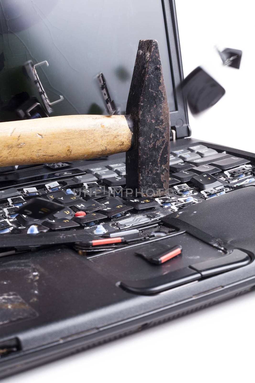 Smashing laptop with black hammer on white background