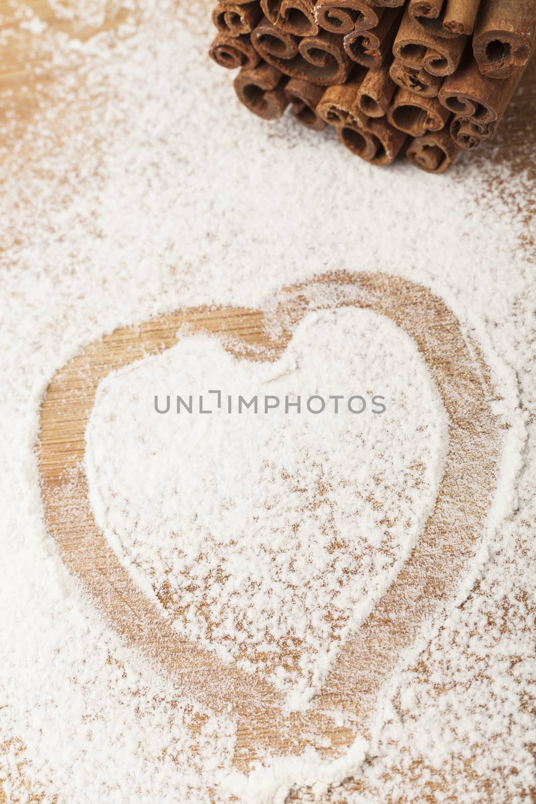 heart shape flour on brown wood cutting board