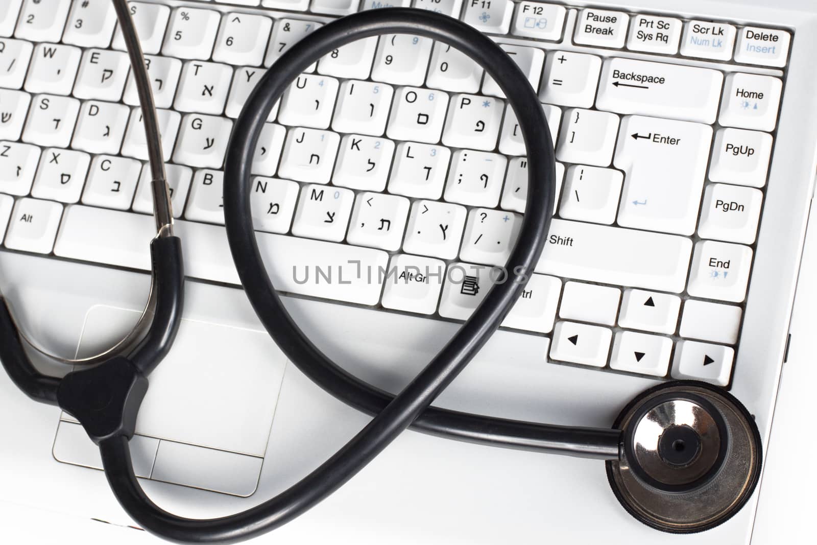 Laptop keyboard closeup with a black stethoscope