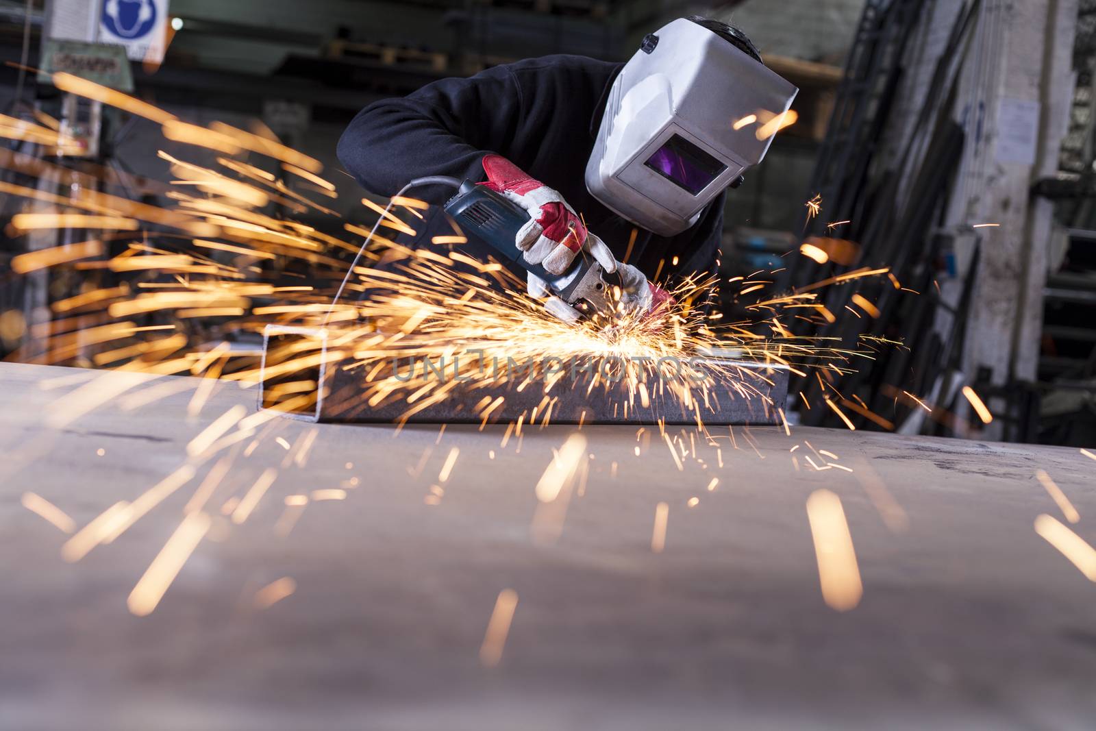 Metal industry worker grinding with mask on the face 