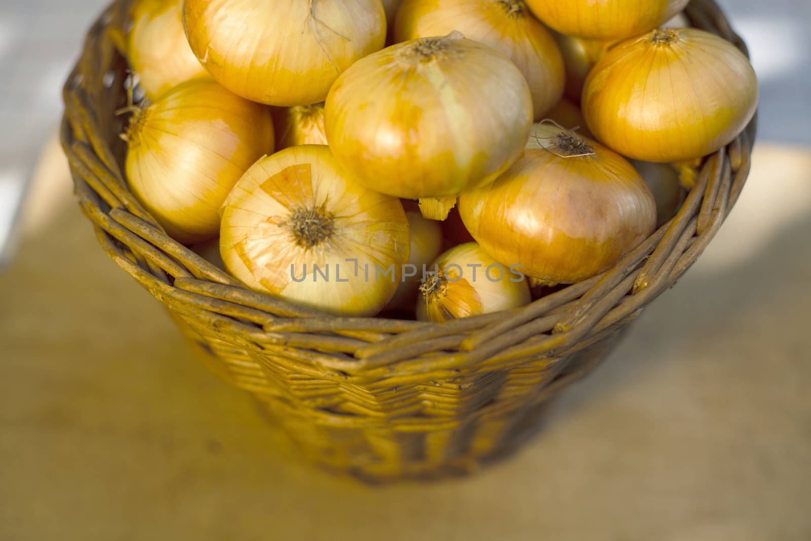 onions in basket close-up on wood backround
