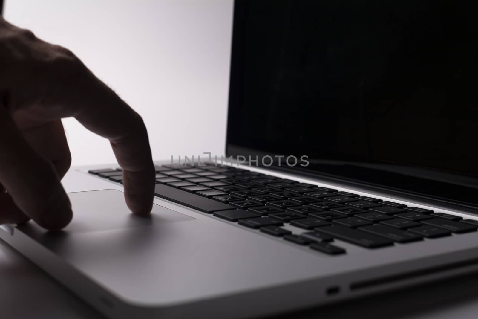 Silver laptop with hand on the trackpad 