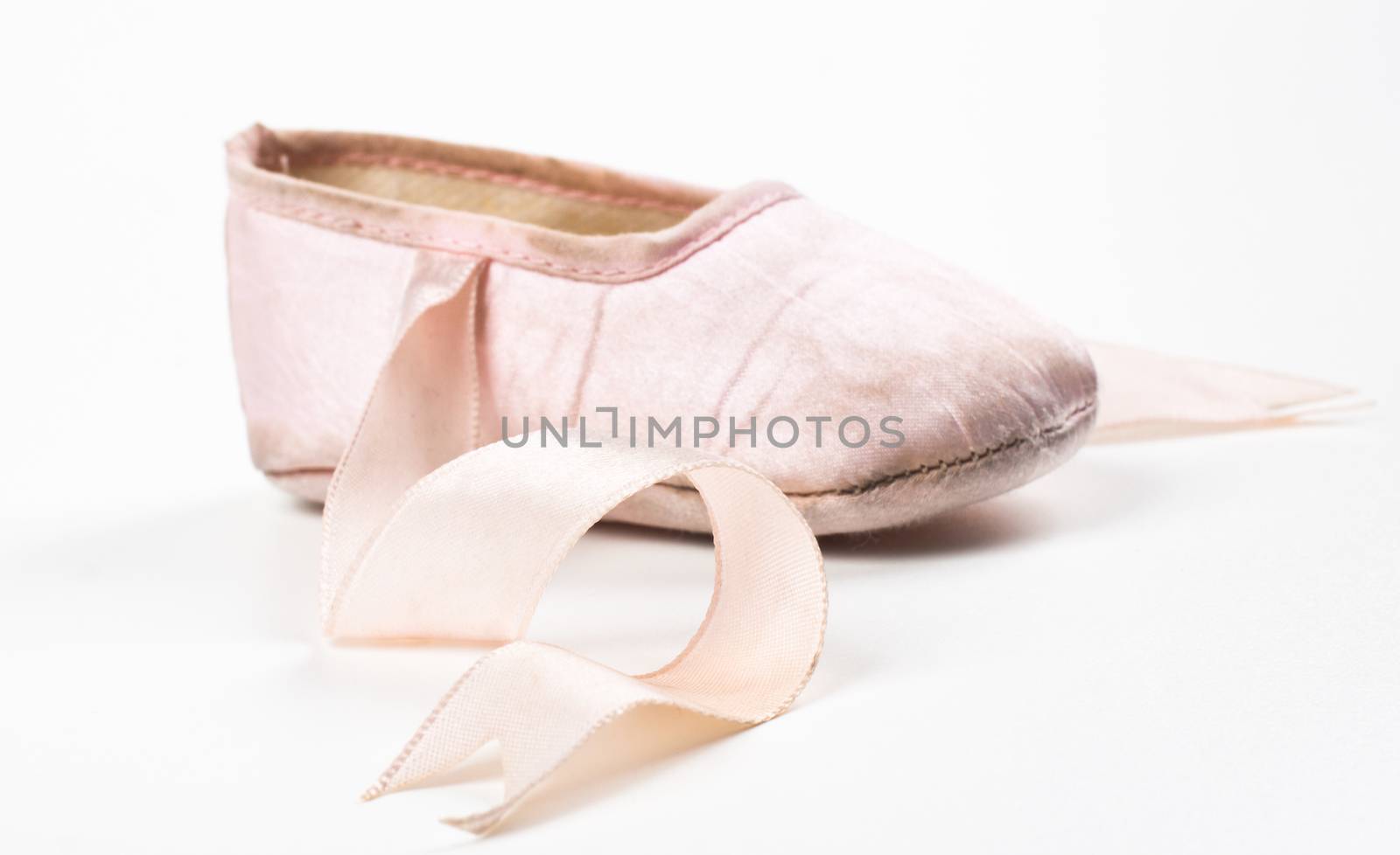 single pink balerina shoe close-up isolaed on white