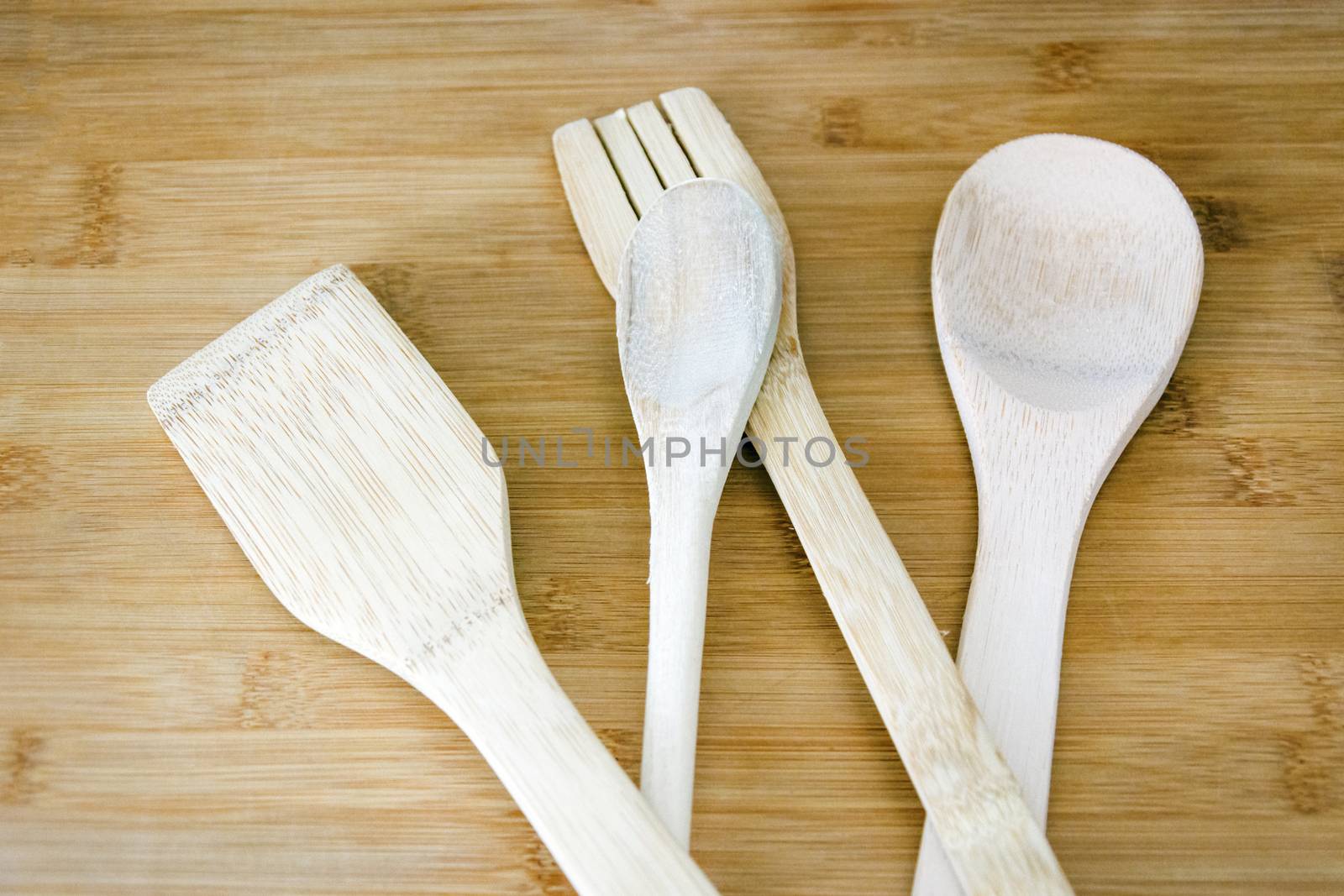 Close up of a group of wooden kitchen utensils on a wooden table