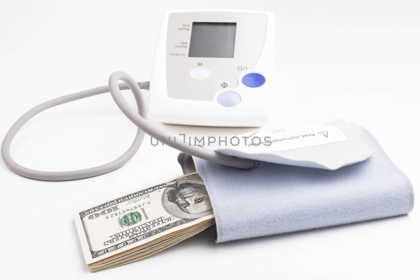 Electronic blood pressure meter with dollar banknotes isolated on white background