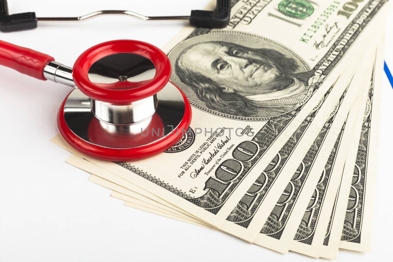 Single red stethoscope on a empty   clipboard  with a pile of dollars