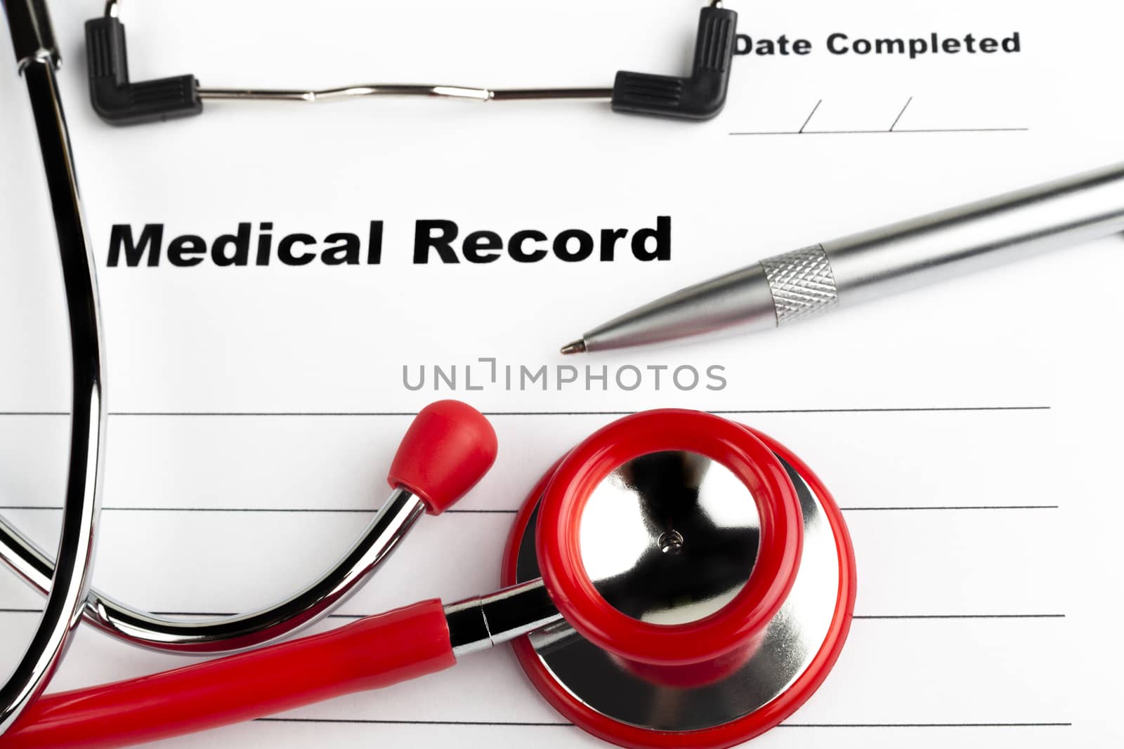 Red stethoscope on  blue clipboard  with medical record close-up with silver colored pen