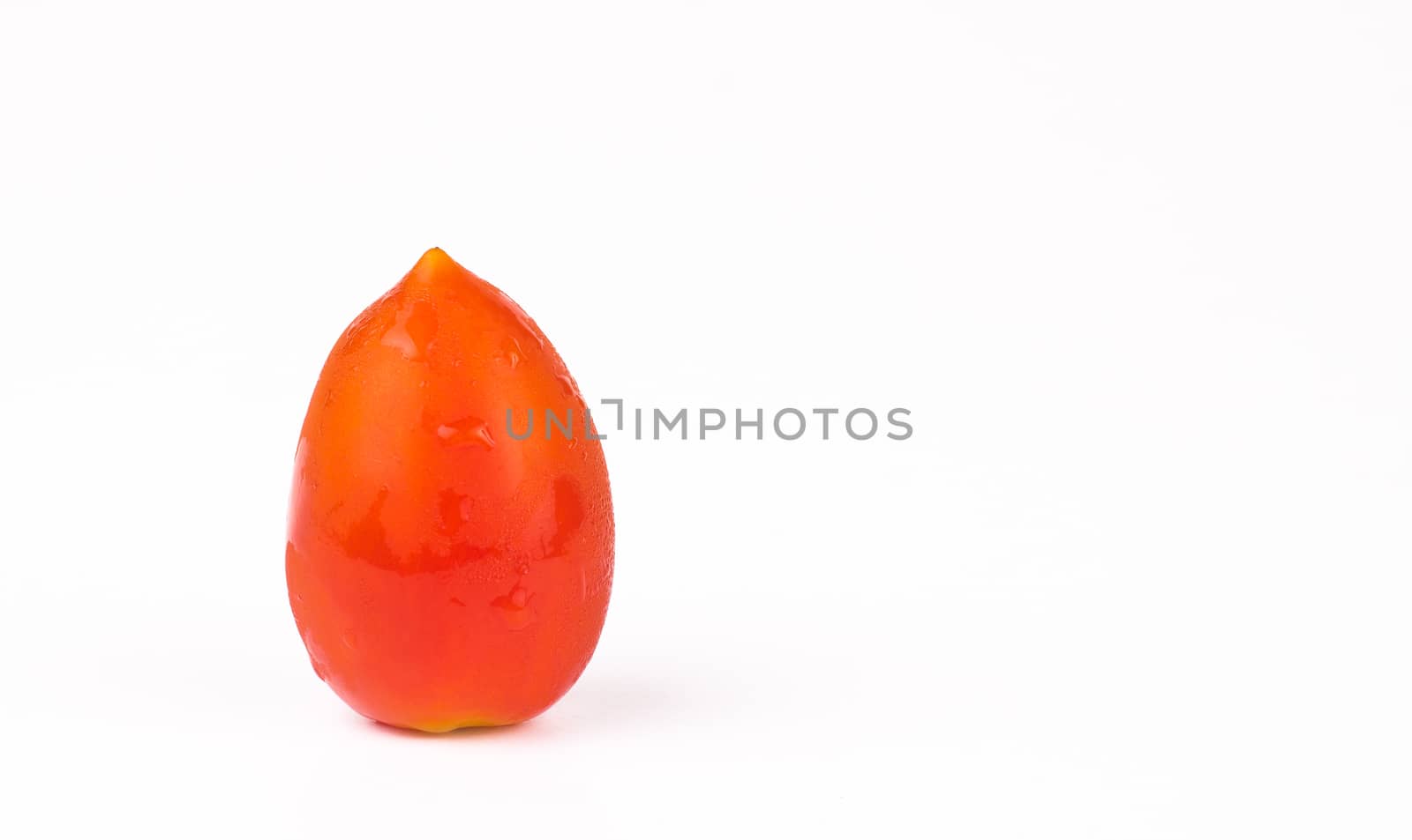 single red cherry tomato with watter drops isolated on white background